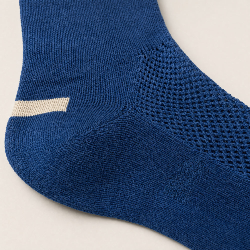 The mesh panel and heel bar of a blue crew sock