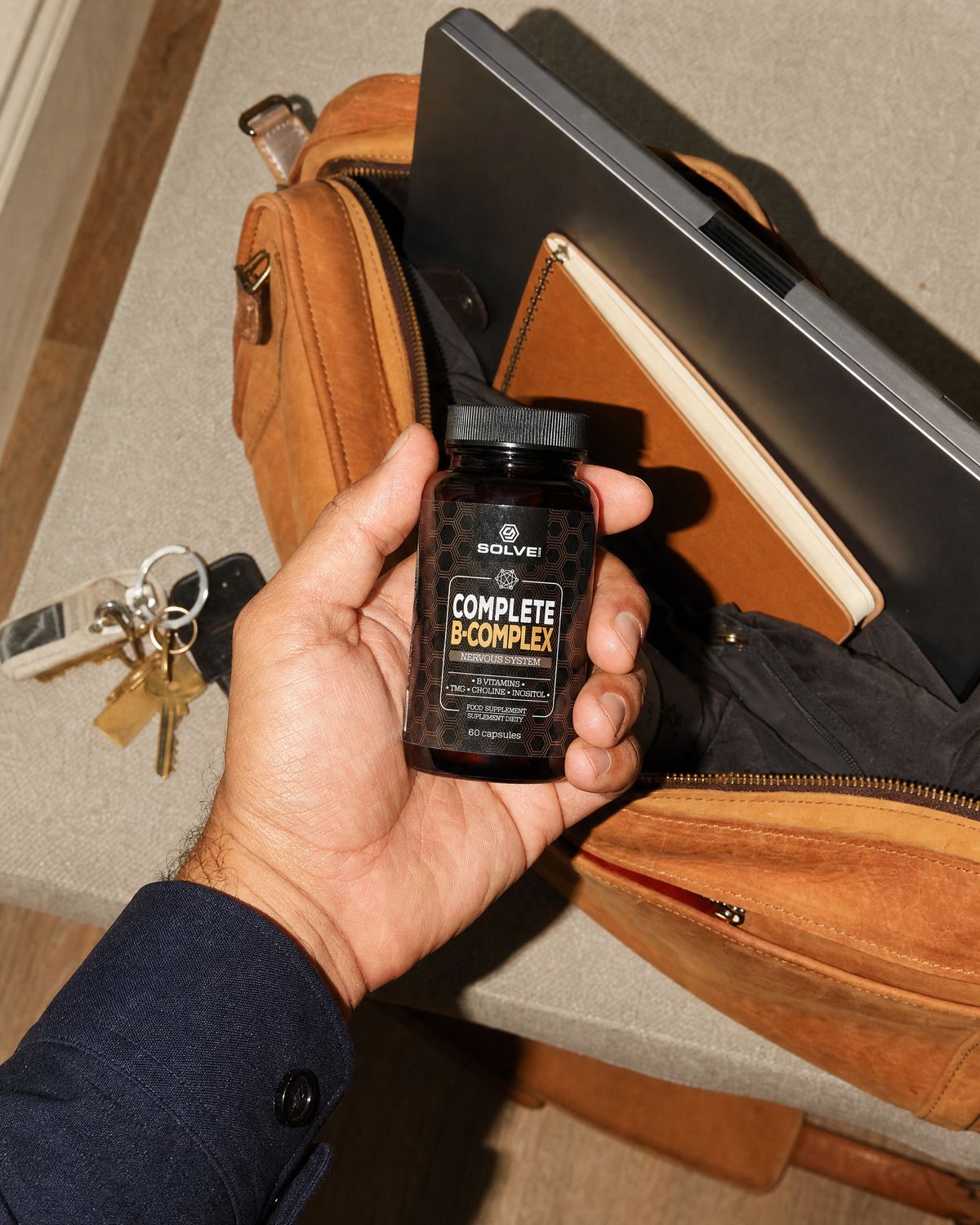 A hand dropping the jar into a leather work bag