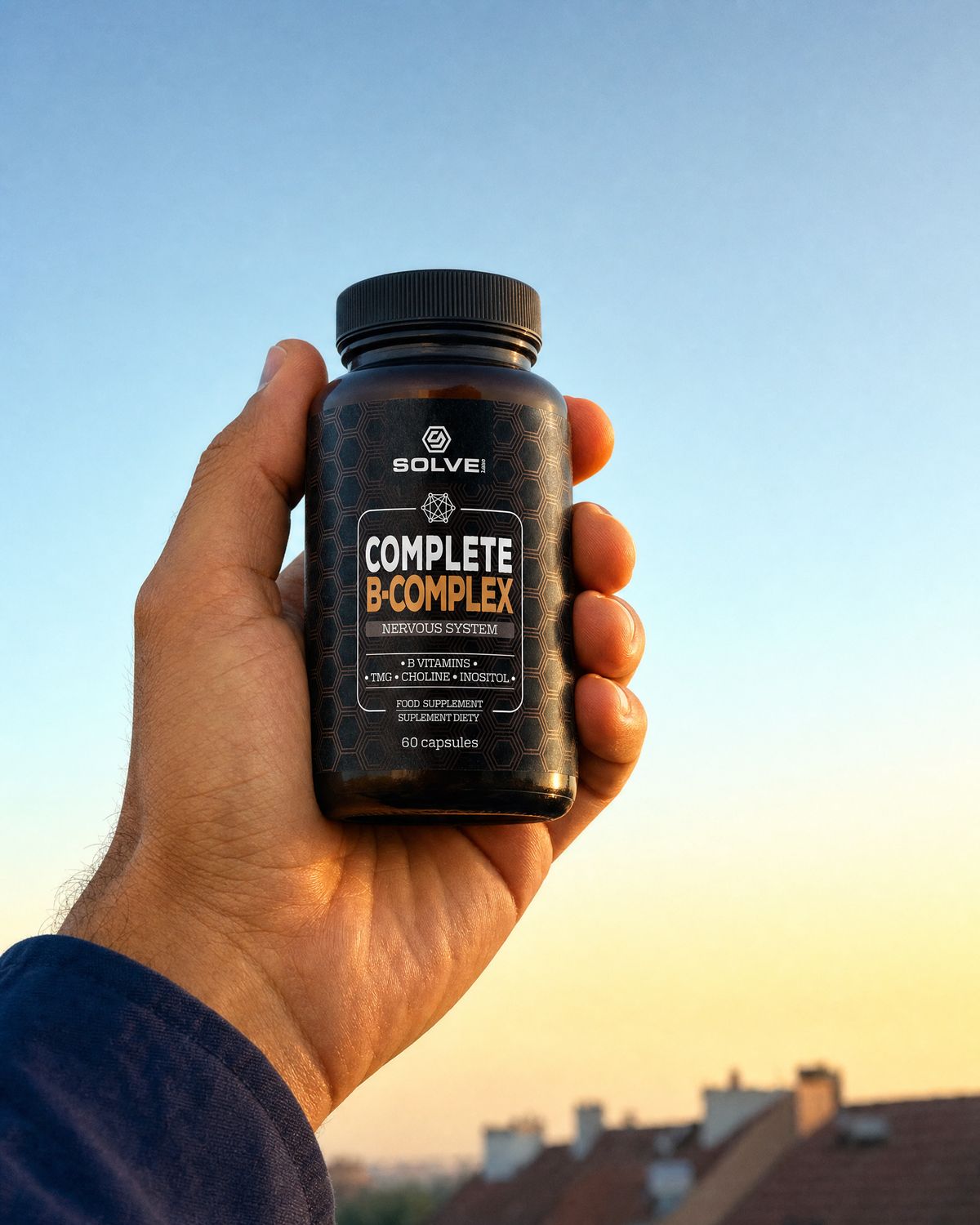 A hand holding up the jar of Solve Labs Complete B-Complex against a golden morning sky