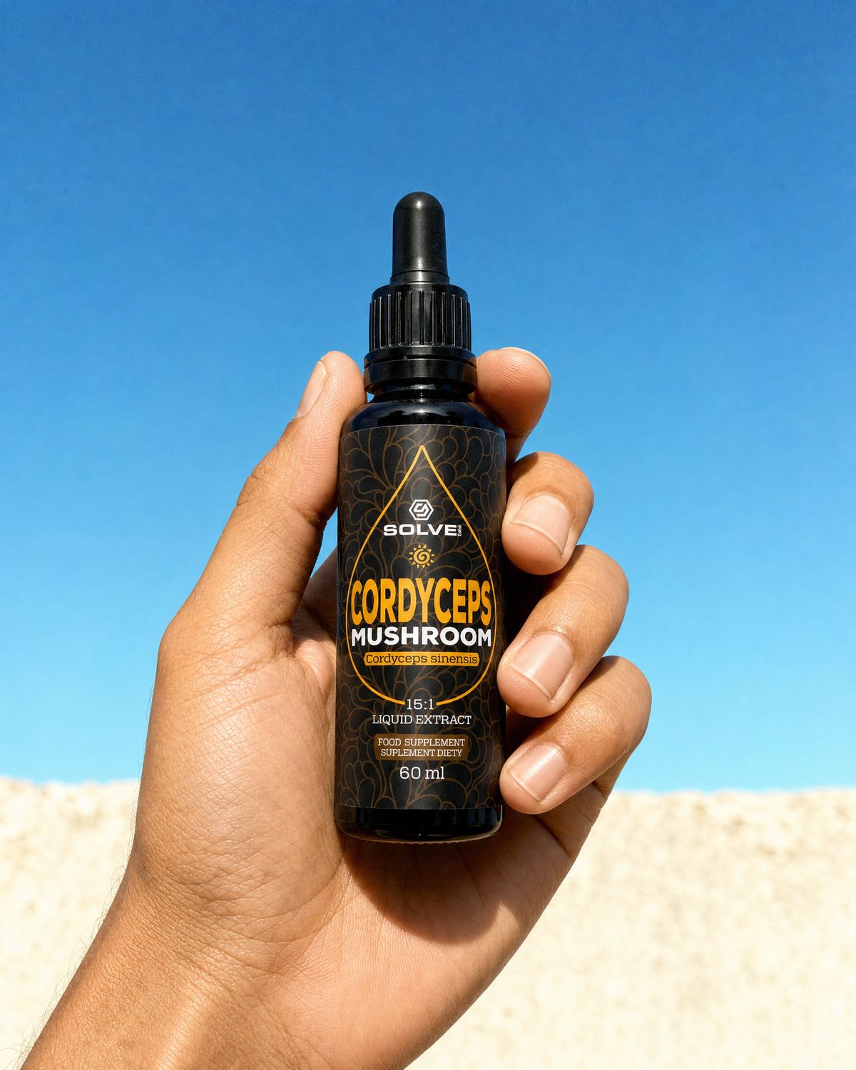 A hand holding up a bottle of Solve Labs Cordyceps drops against a deep blue sky