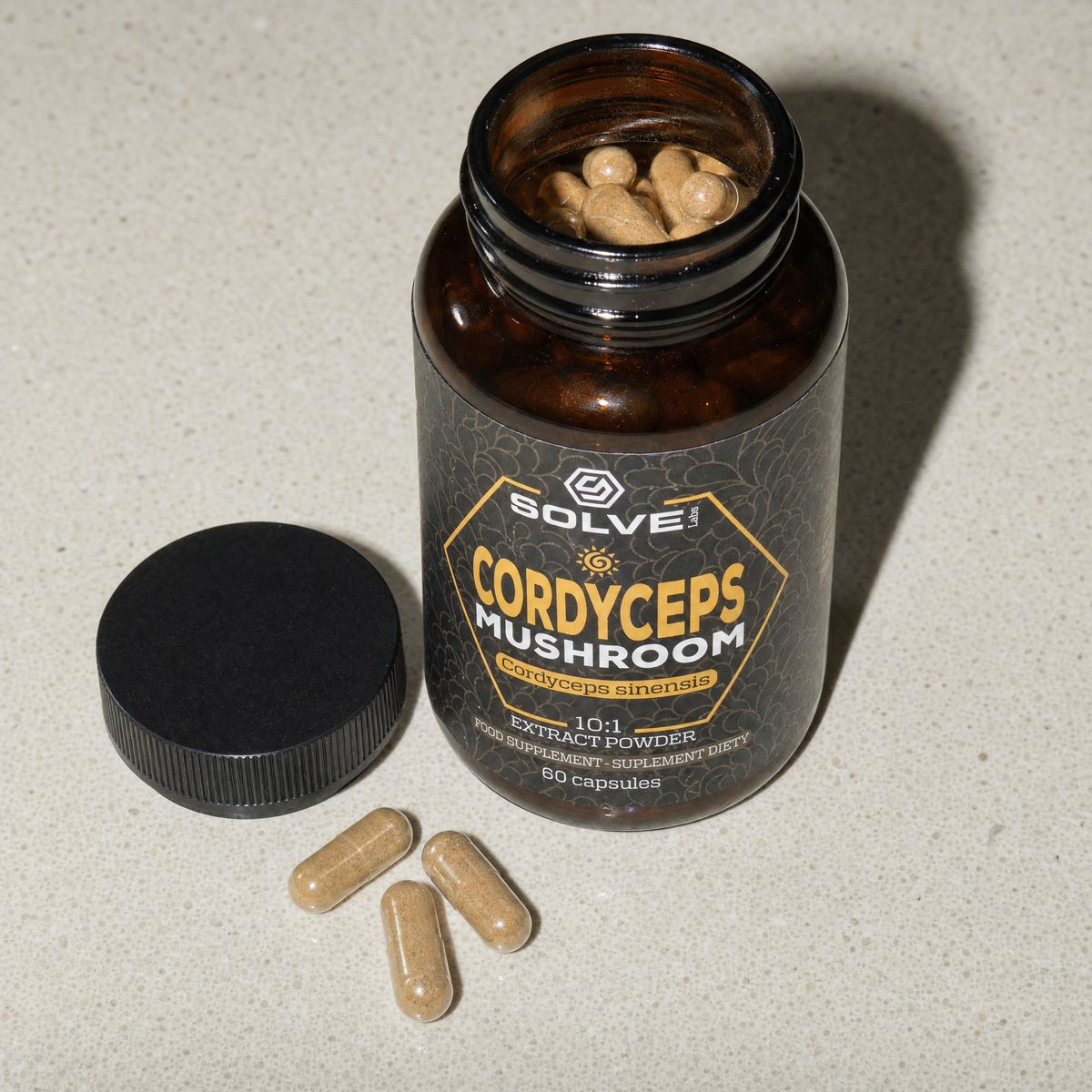 The open jar of Solve Labs Cordyceps capsules, three capsules beside its cap