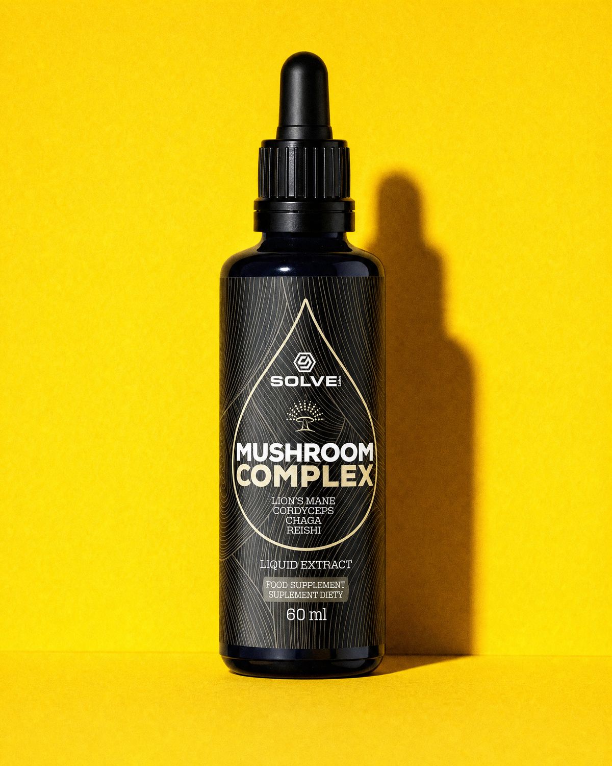 A bottle of Solve Labs Mushroom Complex drops on a mustard-yellow backdrop