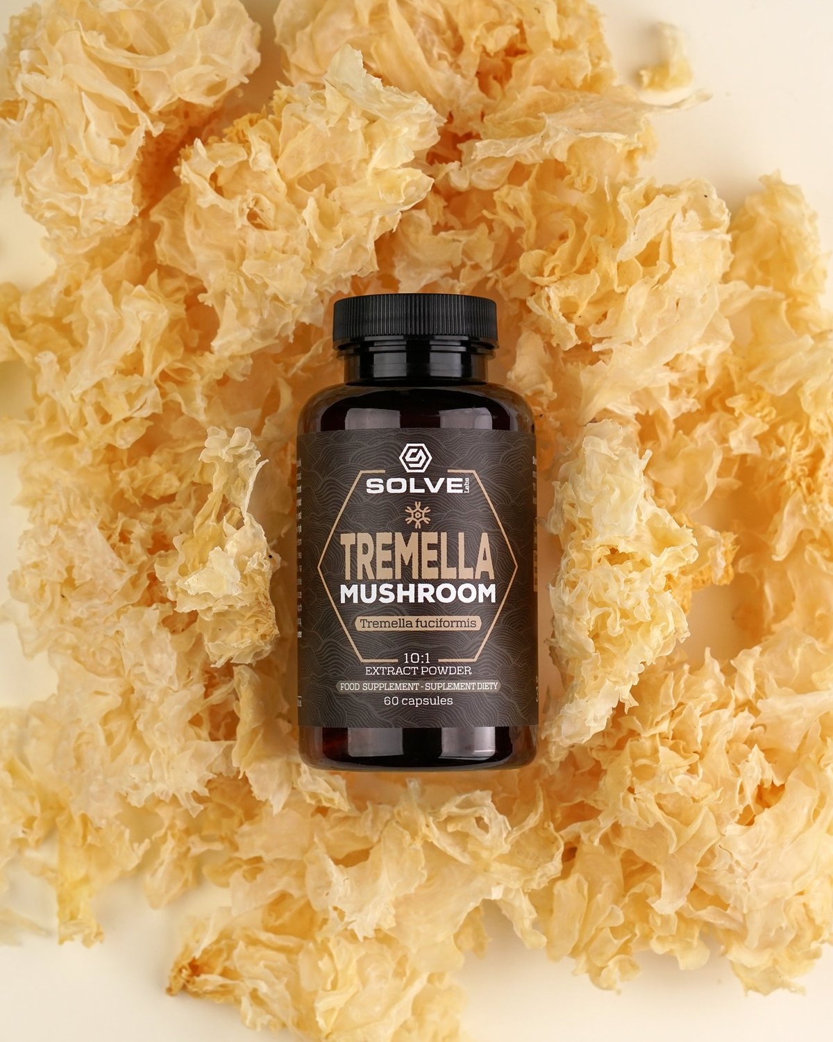 Le pot de gélules de Tremella Solve Labs couché sur un lit de champignons des neiges séchés