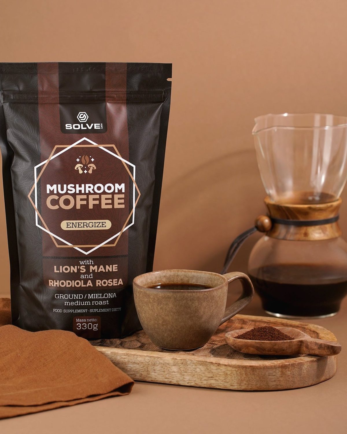 A bag of Mushroom Coffee with Lion&rsquo;s Mane beside a pour-over carafe and a filled stoneware cup