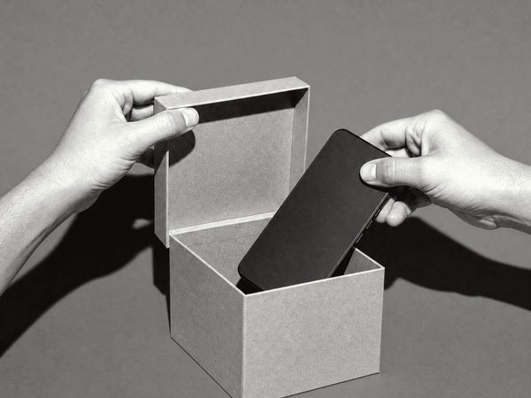 Hands lowering a phone into a box