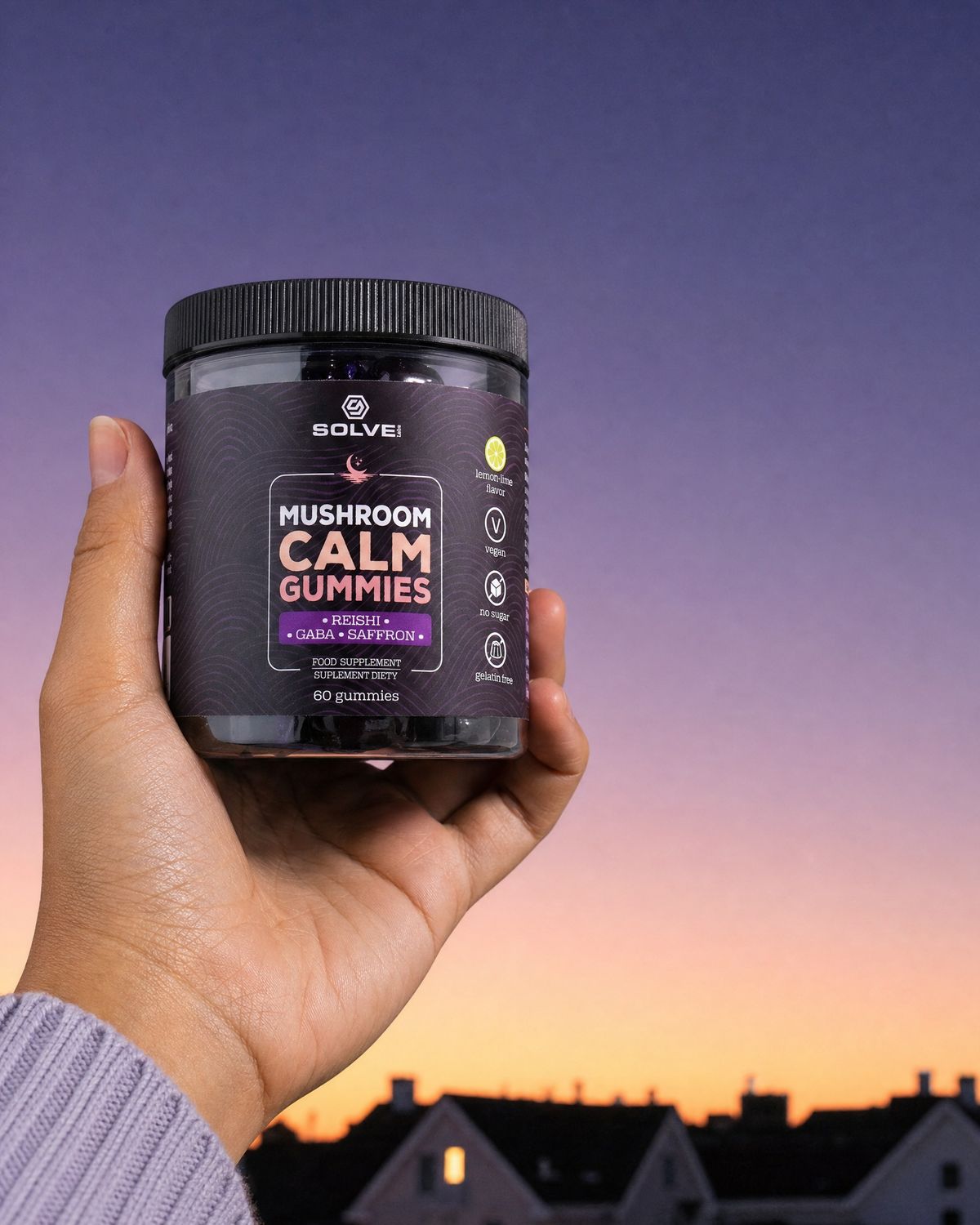 A hand holding up the jar of Solve Labs Mushroom Calm Gummies against a dusk sky
