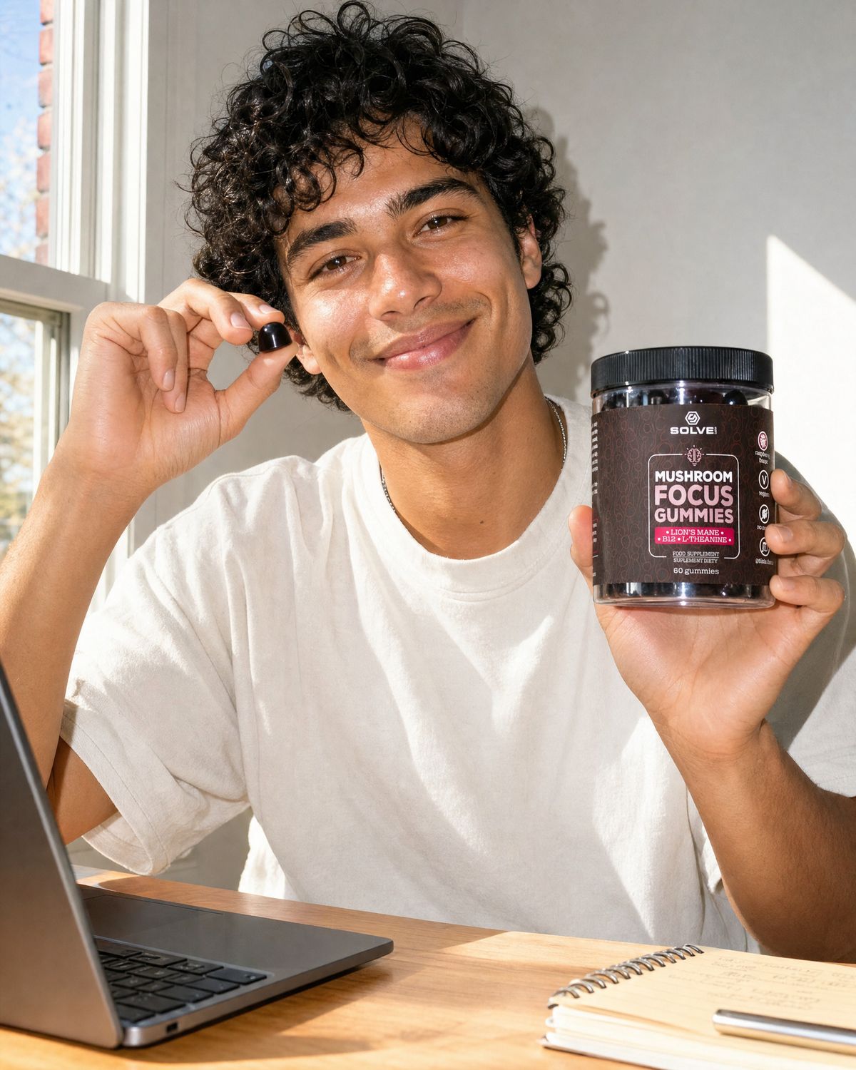 A young man holding up a Focus gummy and the jar