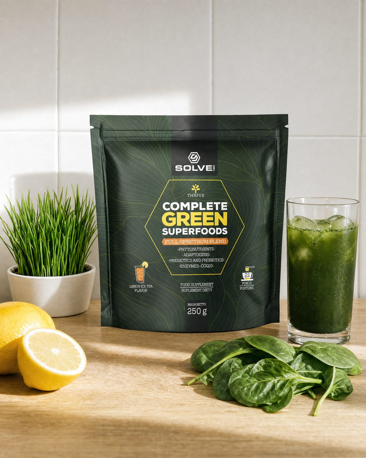 The pouch of Solve Labs Complete Green Superfoods on a kitchen worktop with wheatgrass, spinach, lemons and a glass of the green drink