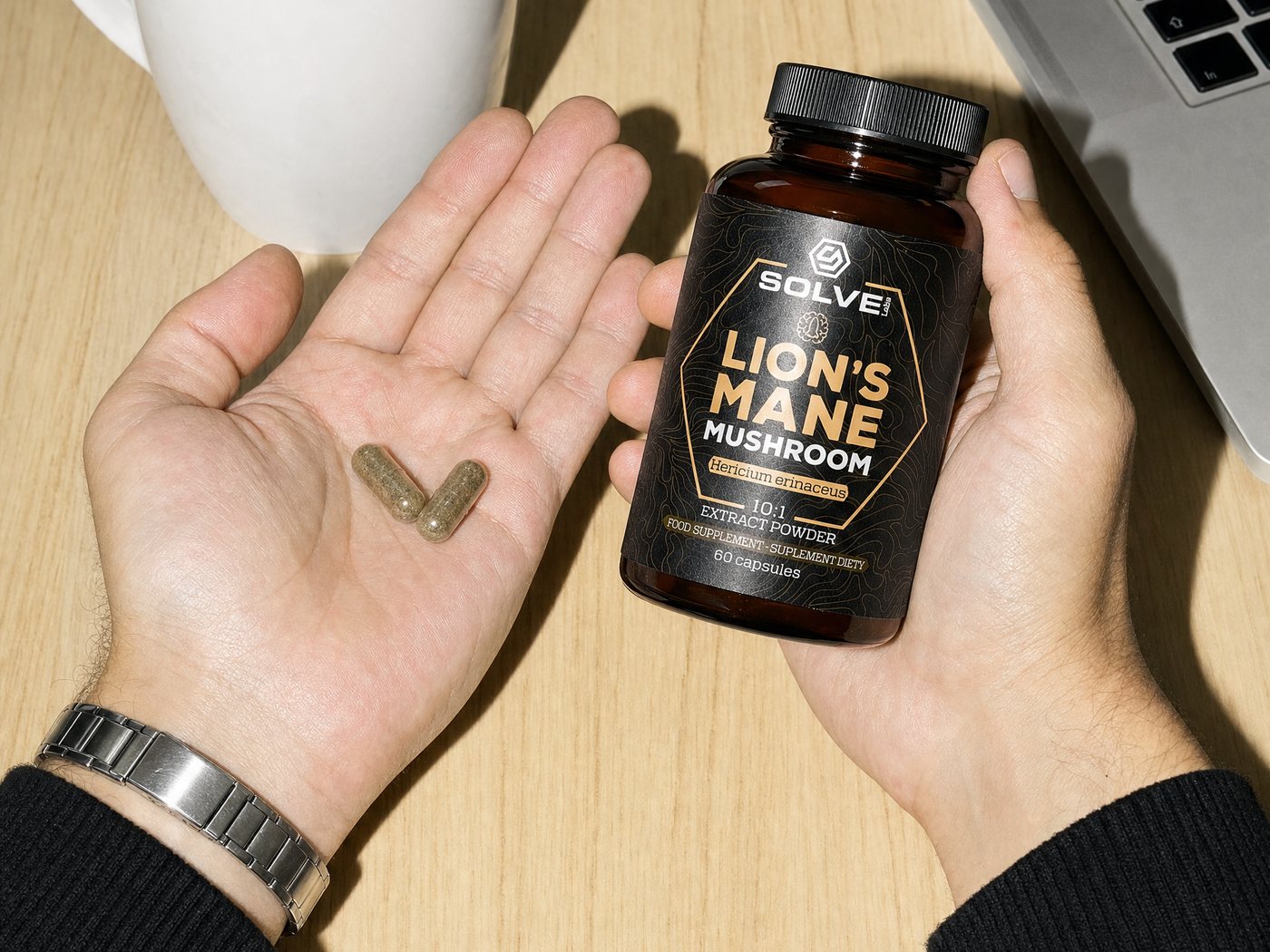 Two Lion's Mane capsules in an open palm beside a cup of coffee, the jar in the other hand