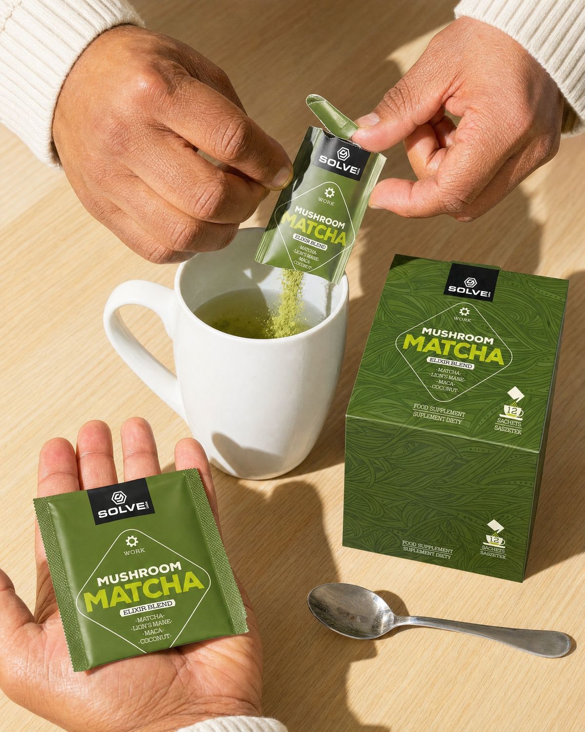 Hands tearing a green sachet and pouring matcha powder into a white mug beside the box