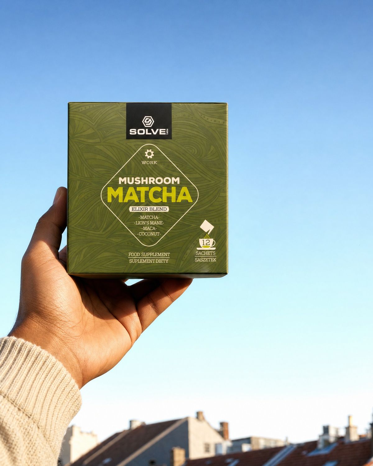 A hand holding up the box of Solve Labs Mushroom Matcha against a clear morning sky