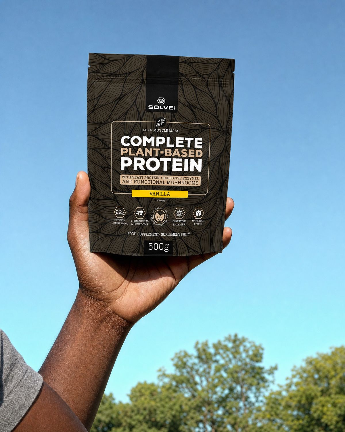 A hand holding up the vanilla pouch of Solve Labs plant protein against a morning sky