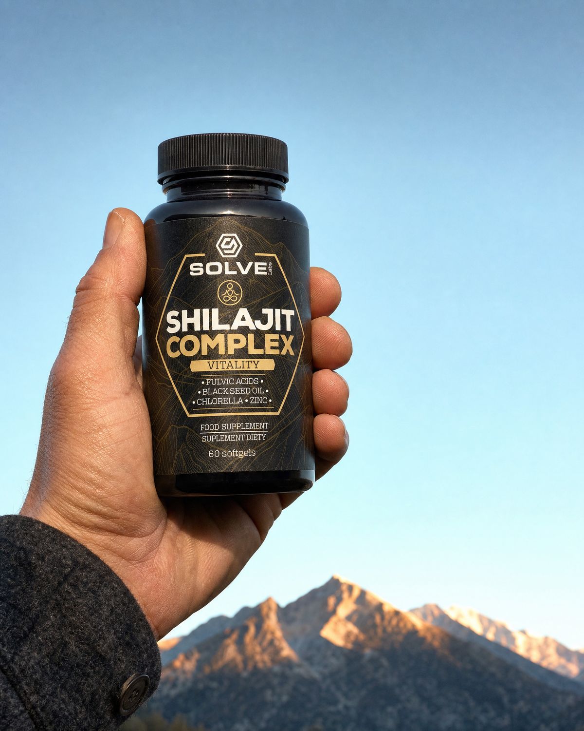 A hand holding up the jar of Solve Labs Shilajit Complex against a mountain sky at dawn