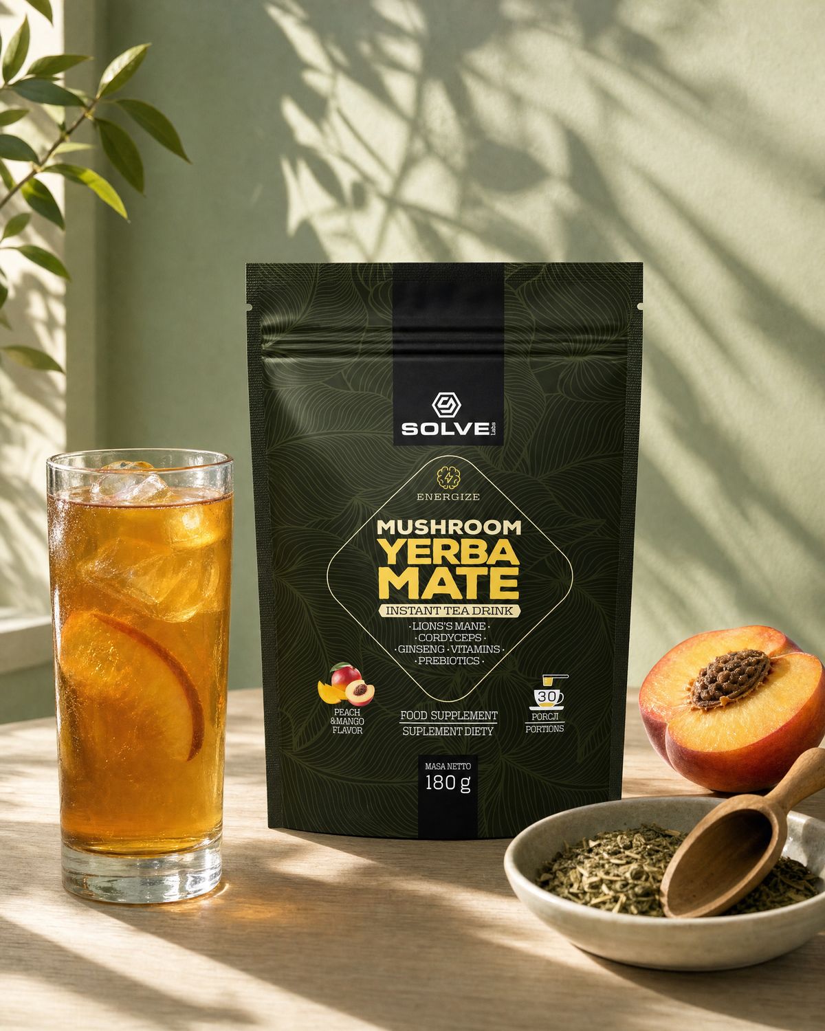 The pouch of Solve Labs Mushroom Yerba Mate on a table in afternoon sun with a glass of the iced drink, a halved peach and a bowl of dried yerba mate leaves