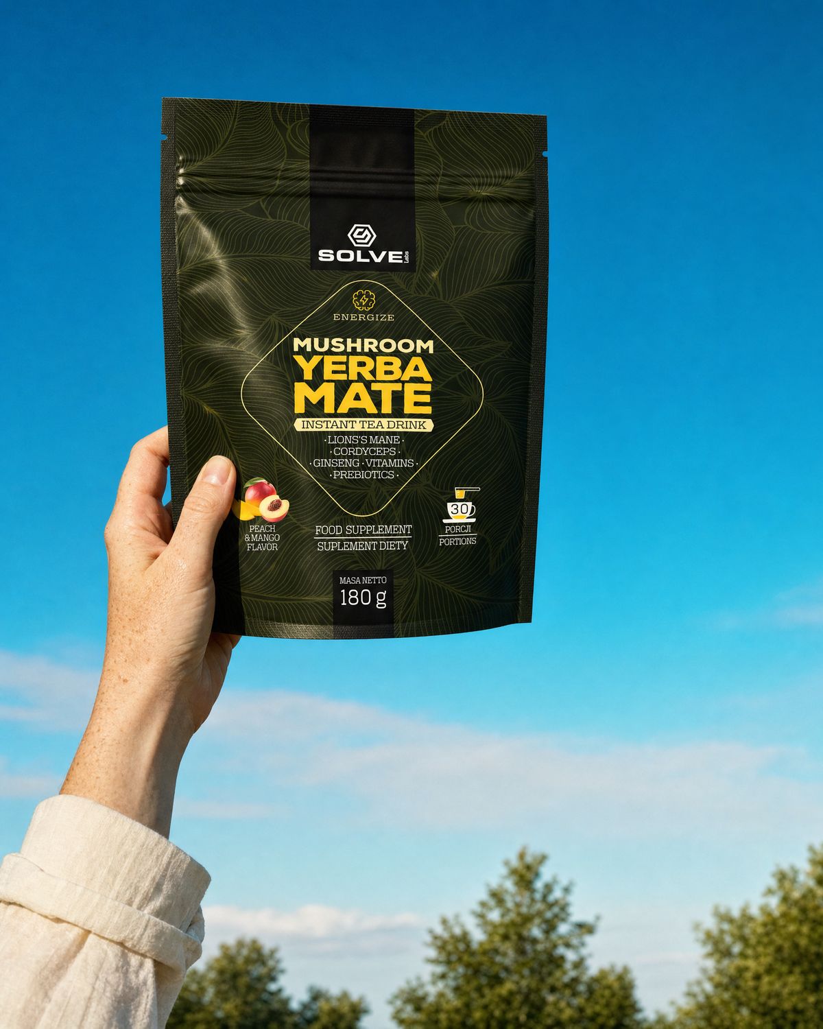 A hand holding up the pouch of Solve Labs Mushroom Yerba Mate against a clear afternoon sky